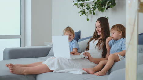 Mother-with-kids-playing-on-laptop-computer